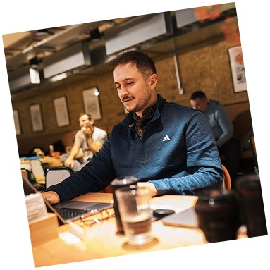 Team member working on a laptop in a bright workspace