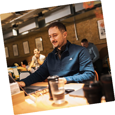 Team member working on a laptop in a bright workspace