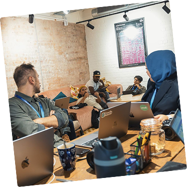 Team meeting around a table with laptops