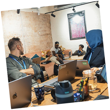 Team meeting around a table with laptops